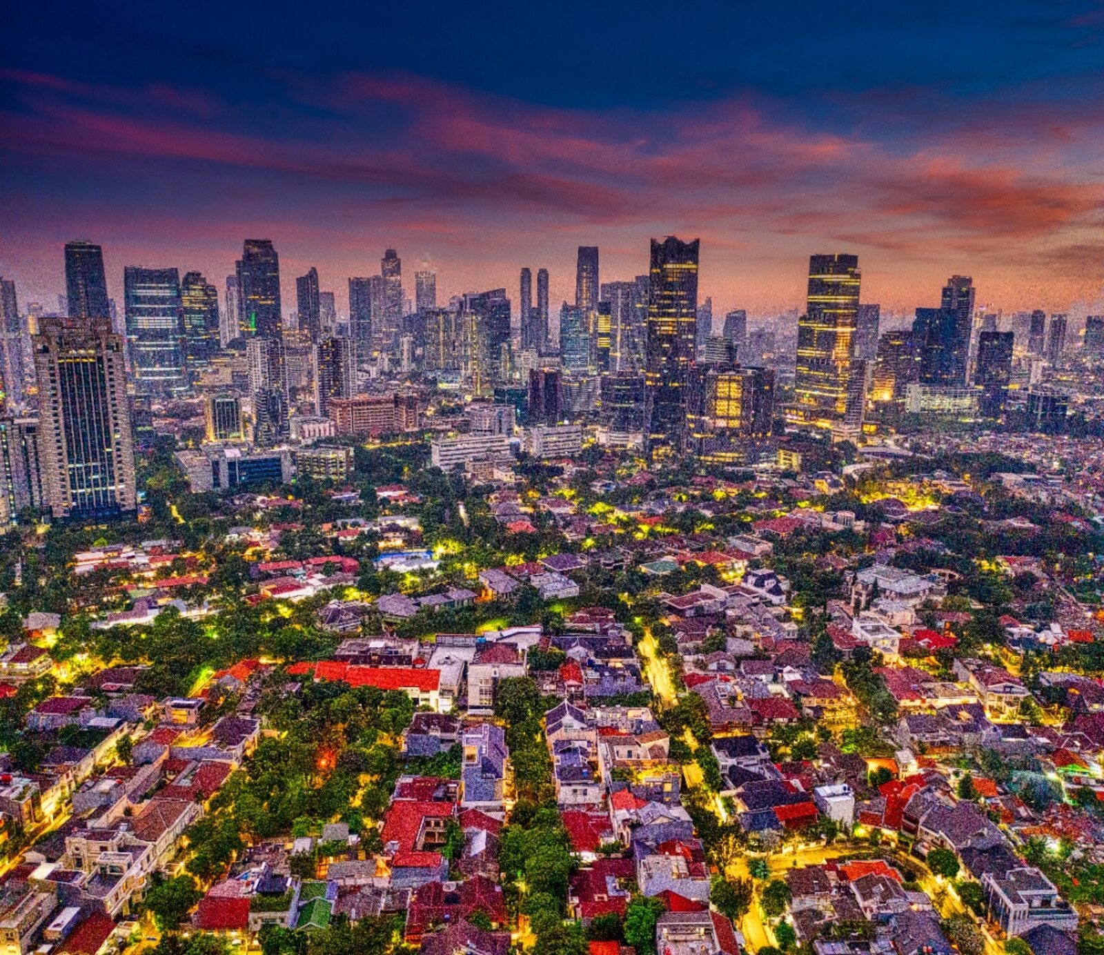 Jakarta skyline at dusk with residential neighbourhoods in the foreground