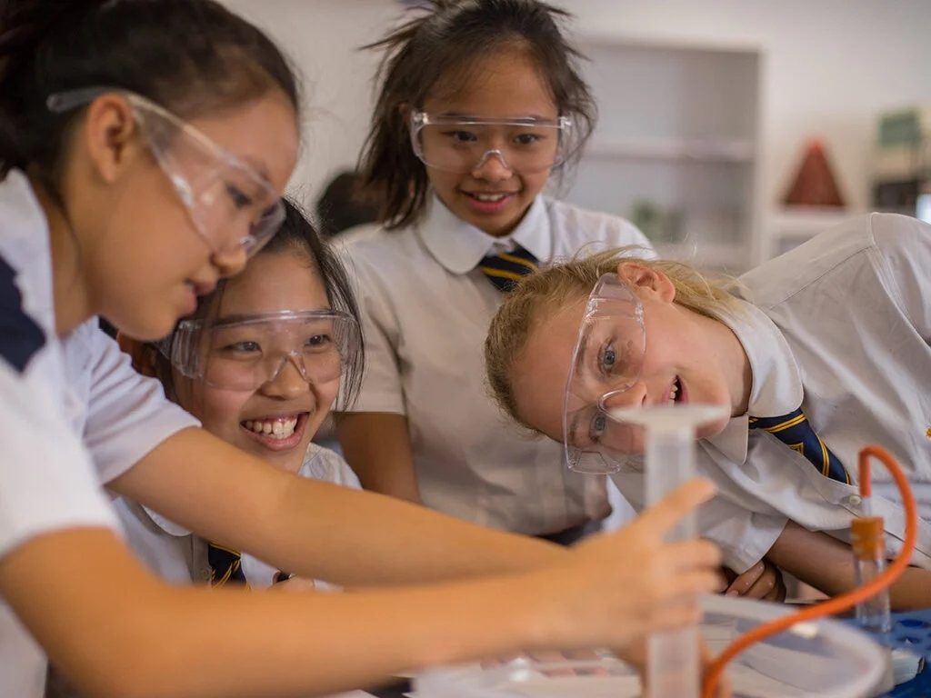 Students in lab goggles conducting a science experiment